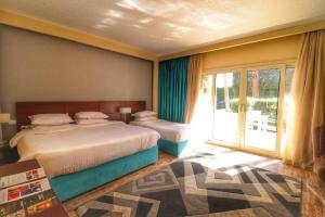 a bedroom with a bed and a sliding glass door at Kemzo Hotel in Abū Rawwāsh