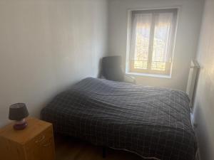 a small bedroom with a bed and a window at Belle appartement in Saint-Mihiel +1 photo