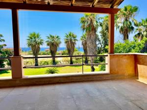 an empty porch with a view of palm trees at Palm Villa Ammes in Svoronata