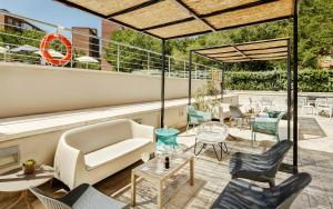 a patio with chairs and a couch and a table at Sercotel Madrid Aeropuerto in Madrid