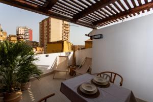 a patio with a table and chairs on a balcony at L'ateneo Lumiére in Agrigento