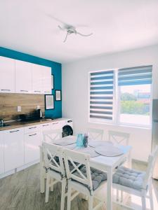 a white kitchen with a white table and chairs at Вила TIMeS in Kiten +59 photos