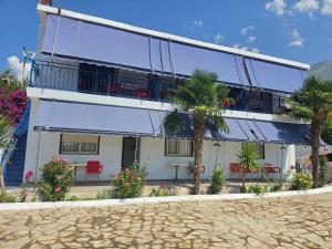 a building with palm trees in front of it at Vila Hana in Dhërmi