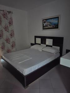 a bedroom with a large bed with white sheets at Vila Hana in Dhërmi +4 photos