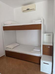 a room with two bunk beds and a refrigerator at Vila Hana in Dhërmi