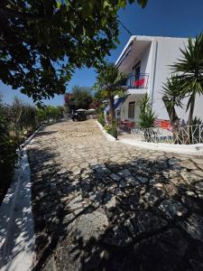 a cobblestone street in front of a white building at Vila Hana in Dhërmi