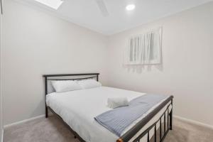 a white bedroom with a large bed in it at Cozy 2BR villa in Maroochydore in Maroochydore
