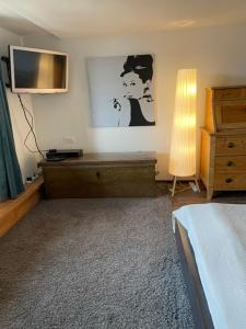 a bedroom with a bed and a dresser and a television at Niesenblick in Aeschlen