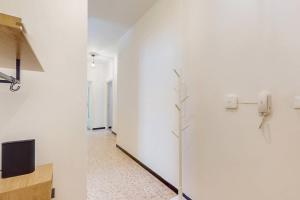 a hallway with white walls and a tv on a wall at [DolciAcque] Dolce sosta nel cuore di Acqui in Acqui Terme