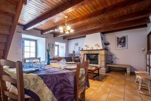 a dining room with a table and a fireplace at Gîte l'anémone 6/7 personnes in Saint-Pierre-des-Tripiers