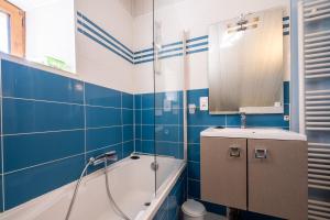 a blue and white bathroom with a tub and a sink at Gîte l'anémone 6/7 personnes in Saint-Pierre-des-Tripiers