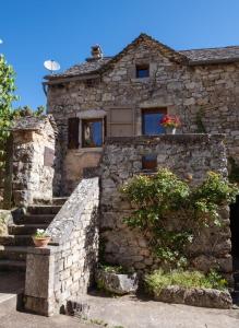 a stone house with a door and some stairs at Gîte l'anémone 6/7 personnes in Saint-Pierre-des-Tripiers
