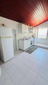 a kitchen with white appliances and a wooden ceiling at Linoq in Montepagano