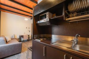 a kitchen with a sink and a couch in a room at Residenza Michetti in Francavilla al Mare