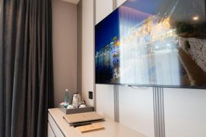 a room with a tv and a desk with a laptop at Buzë Boutique Hotel in Sarandë
