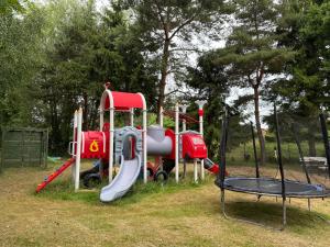 a playground with a slide in a park at Guliwer in Niechorze