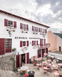 a building with tables and chairs in front of it at Auberge hiribarren in Biriatou