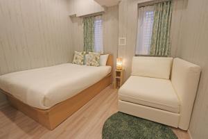 a small bedroom with a bed and a chair at Petit Grande Miyabi in Tokyo +25 photos