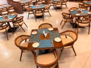 a group of tables and chairs in a restaurant at MOKSH SERENe in Shrīnagar