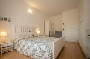 a white bedroom with a bed with a white bedspread at cottage lavanda e rosmarino in Lavis