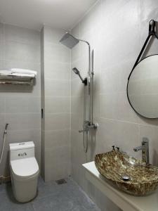 a bathroom with a sink and a toilet and a mirror at AOC HOTEL in Cao Lãnh