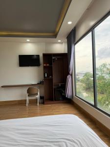 a bedroom with a bed and a large window at AOC HOTEL in Cao Lãnh