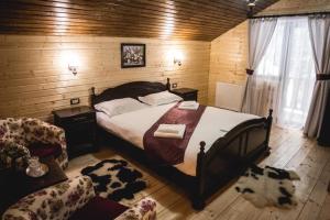 a bedroom with a bed and a couch and a chair at Cabana Iulian in Petrila