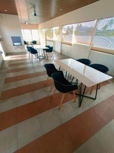 a dining room with tables and chairs and windows at IVY RESIDENCY in Trivandrum