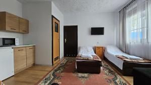 a small room with two beds and a kitchen at Keja II in Łeba