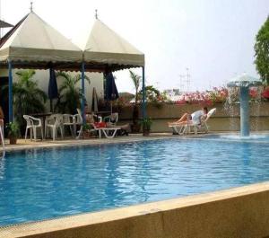 a person sitting in a chair next to a swimming pool at Collection O Ayothaya Hotel in Phra Nakhon Si Ayutthaya