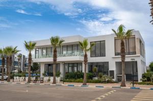 a building with palm trees in front of it at Modern Apartment with Pool & Sea View in Casablanca