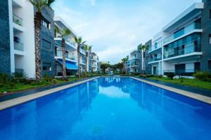 a large blue swimming pool in front of some apartment buildings at Modern Apartment with Pool & Sea View in Casablanca