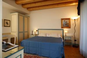 a bedroom with a blue bed in a room at Agriturismo Villa Almè in Oderzo +63 photos