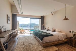 a bedroom with a bed and a desk and a window at XIHUI Cliff Hotel in Tian'ao +234 photos