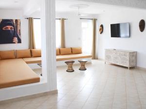 a living room with a couch and a tv at Nyumba Maua B&B in Watamu