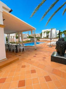 a patio with a table and chairs next to a pool at Villa Bruno in El Toro