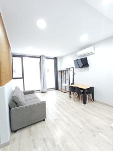 a living room with a couch and a table at Medea Suites Apartamentos in Mérida