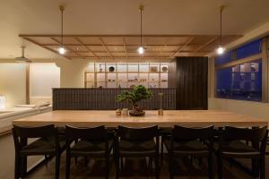 a dining room with a large wooden table and chairs at AO Odawara Lounge in Odawara
