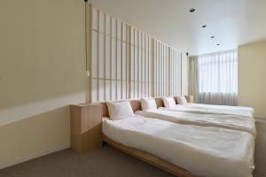 a bedroom with two beds with white sheets at AO Odawara Lounge in Odawara
