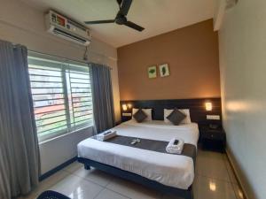 a bedroom with a large bed and a window at IVY RESIDENCY in Trivandrum +27 photos
