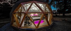 a small wooden greenhouse with a bed in it at Dôme Bao SPA luxe climatisé in Lesterps