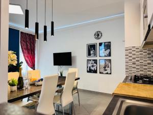 a dining room with a table and white chairs at Nice apartment in the historic center in Verbania