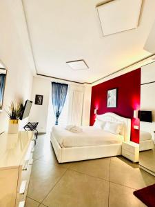 a bedroom with a white bed and a red wall at Nice apartment in the historic center in Verbania