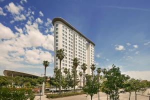 a tall white building with palm trees in a parking lot at Sercotel Sorolla Palace in Valencia +58 photos