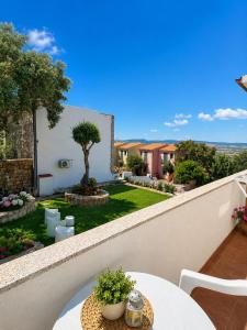 a balcony with a table and a garden at BeB con piscina Villa del Borgo in Badesi