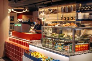 a woman standing at the counter of a restaurant at Scandic Go, Eerikinkatu 30 in Turku