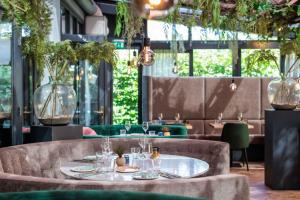 a restaurant with tables and chairs and plants at Hotel 't Paviljoen in Rhenen