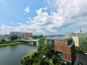 a view of a river with buildings and a bridge at Apartament Piano 21 in Opole