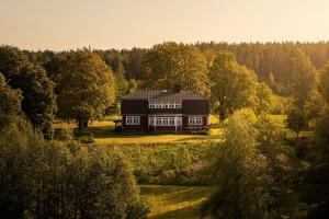 a large house in the middle of a field with trees at Stay North - Marjaniemi in Salo