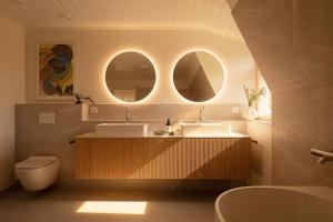a bathroom with two sinks and two mirrors at Stay North - Marjaniemi in Salo +95 photos